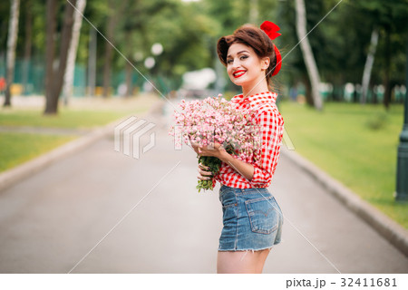 Pinup girl with bouquet of flowers, retro fashion 32411681