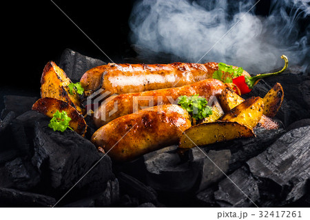 Fried sausages with potatoes and hot pepper on a c 32417261