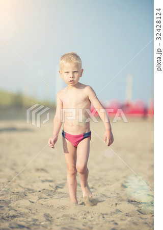 Cute baby boy walking on sandy beach near the sea Cute baby boy walking on sandy beach near the sea 32428124