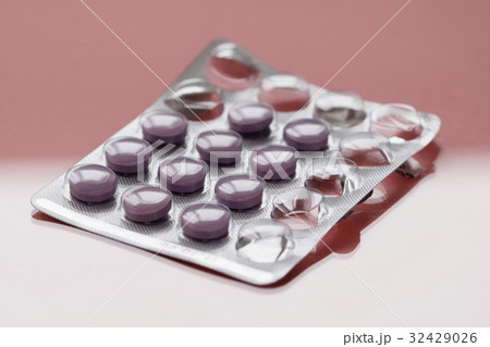 Close-up of purple pills in a pack on a pink Close-up of purple pills in a pack on a pink 32429026