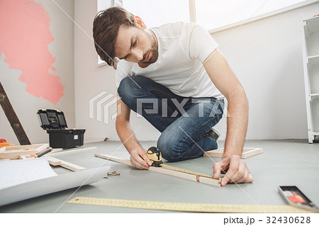 Young man does apartment repairment himself Young man does apartment repairment himself 32430628