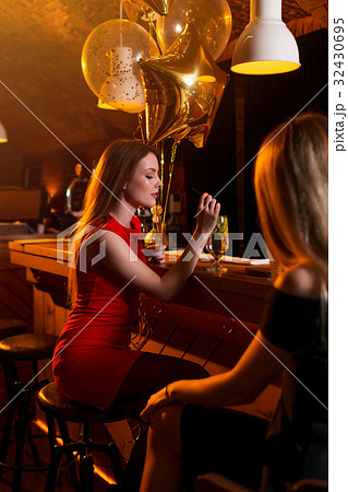 Portrait of birthday girl sitting with a glass of 32430695