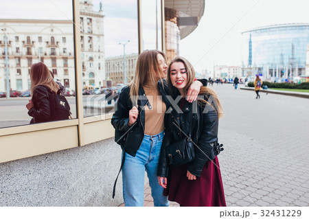 Two friends meeting in the street and hugging 32431229