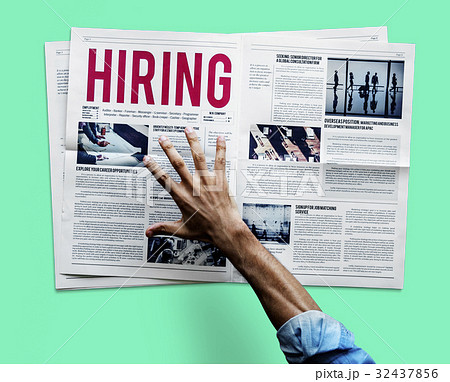 Hand reaching to grab newspaper for hiring job announcement Hand reaching to grab newspaper for hiring job announcement 32437856