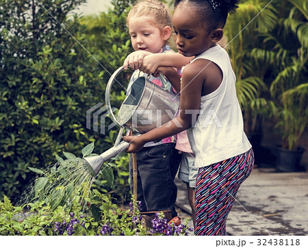 Children are in the garden watering the plants 32438118