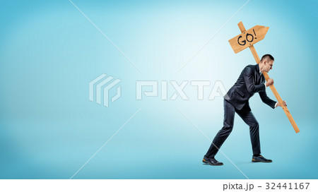 A businessman on blue background holding a heavy A businessman on blue background holding a heavy 32441167