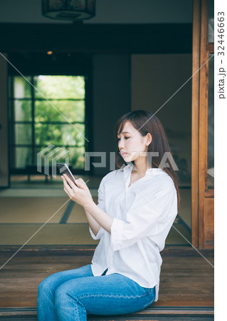 縁側でスマホを見る女性 32446663