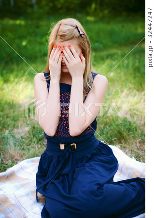 girl covered her eyes with her hands 32447247