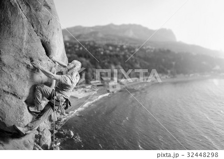 Male climber climbing big boulder in nature with rope Male climber climbing big boulder in nature with rope 32448298