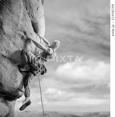 Male climber climbing big boulder in nature with rope Male climber climbing big boulder in nature with rope 32448299