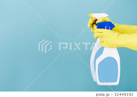 Hand in yellow glove holds  spray bottle of liqui 32449192