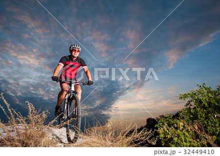 Cyclist on mountain bike races downhill in the nature 32449410