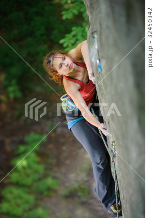 Beautiful woman climber climbing steep rock with rope Beautiful woman climber climbing steep rock with rope 32450342
