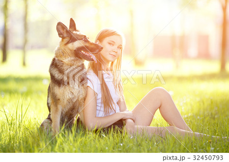 Teenage girl with her dog sitting in park Teenage girl with her dog sitting in park 32450793