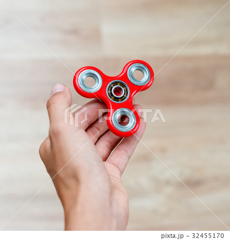 Fidget spinner. Red hand spinner, fidgeting hand Fidget spinner. Red hand spinner, fidgeting hand 32455170