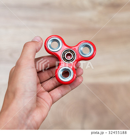 Fidget spinner. Red hand spinner, fidgeting hand Fidget spinner. Red hand spinner, fidgeting hand 32455188