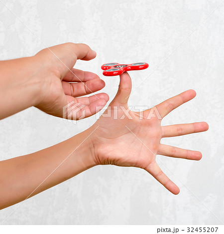 Fidget spinner. Red hand spinner, boys playing Fidget spinner. Red hand spinner, boys playing 32455207
