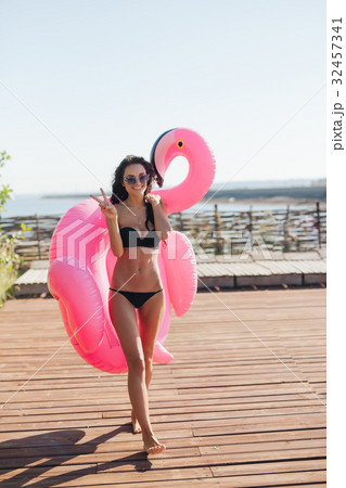 woman holding pink inflatable flamingo float 20s woman holding pink inflatable flamingo float 20s 32457341