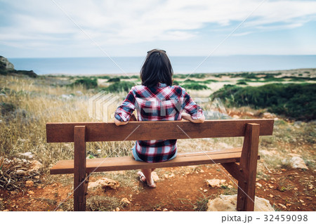 Woman enjoying sea view sitting on a bench in beautiful valley Woman enjoying sea view sitting on a bench in beautiful valley 32459098