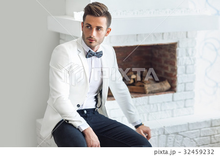 Handsome stylish man in elegant suit sitting near fireplace 32459232