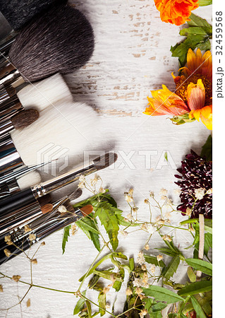 Make up accessories next to wild flowers 32459568