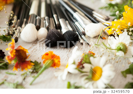 Make up accessories next to wild flowers 32459570