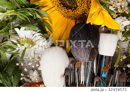 Make up accessories next to wild flowers 32459572