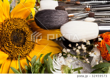 Make up brushes on a pile of wild flowers 32459573
