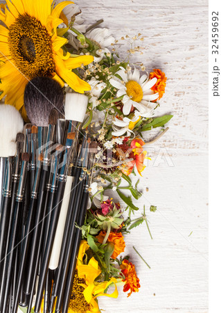 Make up brushes on a pile of wild flowers 32459692