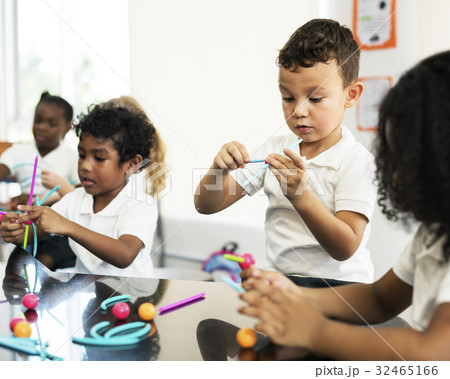 Diverse kindergarten students holding learning structures from toys 32465166