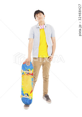 young man standing and holding a skateboard young man standing and holding a skateboard 32468427