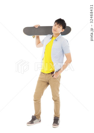 young man standing and holding a skateboard 32468431