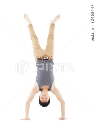 young man doing a handstand against on white young man doing a handstand against on white 32468447
