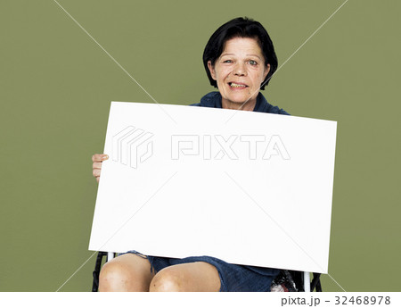 Senior adult woman on wheelchair holding blank banner Senior adult woman on wheelchair holding blank banner 32468978