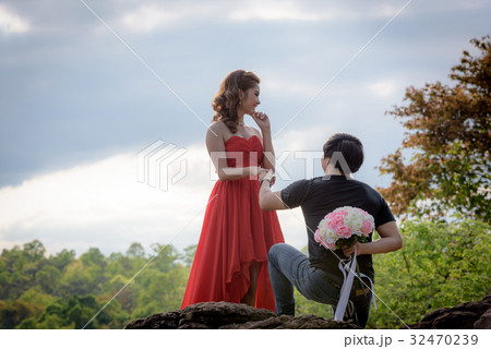 bouquet in the hands of a young man hidden behind. 32470239