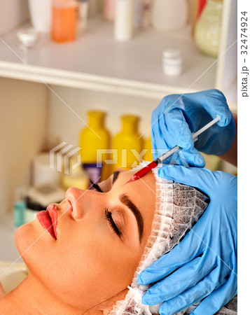 Filler injection for woman forehead face. Plastic 32474924