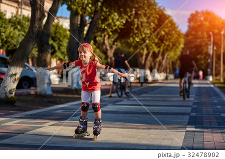 Pretty little girl in red cloth learning to roller Pretty little girl in red cloth learning to roller 32478902