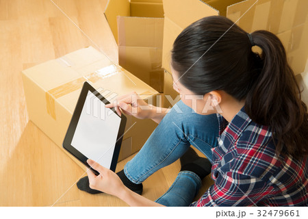 female moving new house checking on digital tablet 32479661