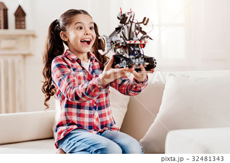 Positive delighted little female looking at her Positive delighted little female looking at her 32481343