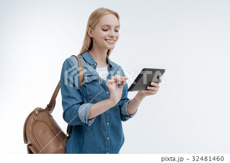Attractive smiling woman looking at her tablet Attractive smiling woman looking at her tablet 32481460