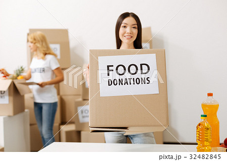 Wonderful young woman carrying a box with 32482845
