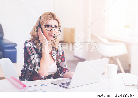 Cheerful call center operator sittign in the 32483667