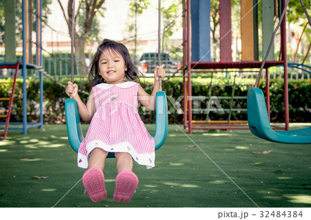 Child asian little girl having fun to play swing Child asian little girl having fun to play swing 32484384