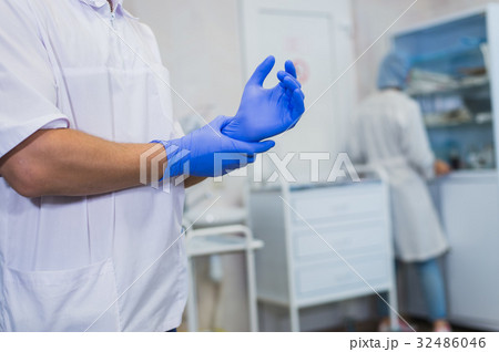 The surgeon wears gloves before surgery. Close-up 32486046