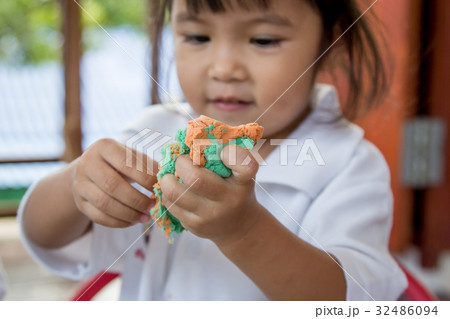 Child cute little girl playing with clay, play doh Child cute little girl playing with clay, play doh 32486094