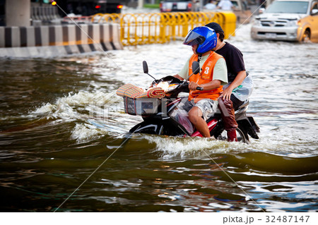 motorbike navigating through the flood motorbike navigating through the flood 32487147
