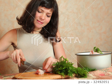 housewife cooking with chicken meat and green dill housewife cooking with chicken meat and green dill 32492051