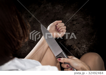 woman holding knife and contemplating suicide woman holding knife and contemplating suicide 32492464