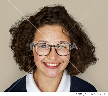 Portrait studio shoot of schoolgirl in uniform with smiling 32498724