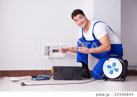 Young electrician working on socket at home Young electrician working on socket at home 32500844